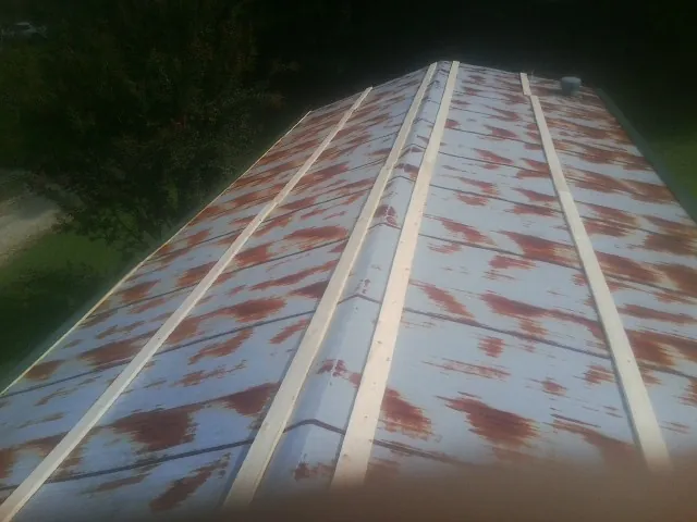Rusted metal roof panels with new wood purlins before replacement — Storm Damage Roof Repair in Parrish by Roofing Brothers